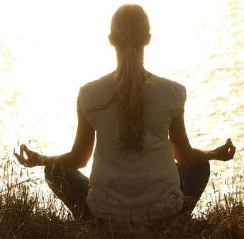 femme en posture de méditation au bord de l'eau
